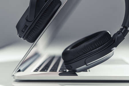 Modern Laptop Computer and Professional Wireless Headphones Digital Audio Mixing Concept. Working with Audio Files. Music Industry.の写真素材