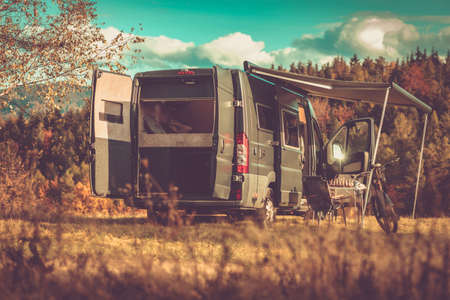 Family Camper with Tent Parked in a Calm Place Surrounded by Nature. All Doors of the Van are Open,...