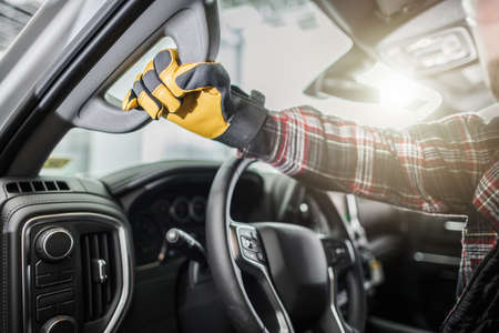 Closeup of a Menâ€™s Hand in Yellow Work Gloves Holding On to the Handle When Getting Out of...