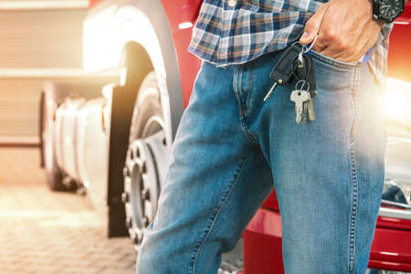 Trucker Dressed in Denim Trousers Patiently Waiting For a Cargo to Be Loaded Carrying His Truck Keys Sticking Out of His Pocket.の写真素材