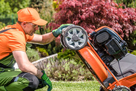 Closeup of Caucasian Male Gardener in His Work Wear Carefully Checking His Professional Gardening...