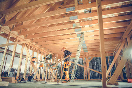 Contractor Matching and Adjusting Planks of Wood with Professional Circular Saw to Complete a Wooden...