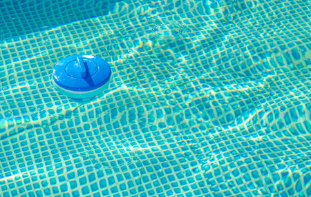 Plastic Made Floating Outdoor Swimming Pool Chemical Chlorine Dispenser Inside a Pool. Water Treatment Theme.の写真素材