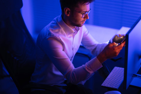 Caucasian Businessman Focused on Data Processing While Working Late in His Office. business theme.