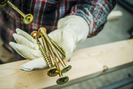 Large Heavy Duty Wood Construction Screws in the Worker Hands. Woodworking Theme.の写真素材