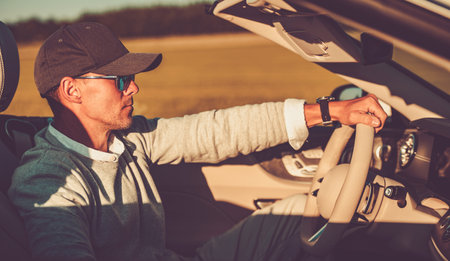 Closeup of Wealthy Caucasian Man in His 40s Driving His Modern Convertible with Retracted Roof. Open...