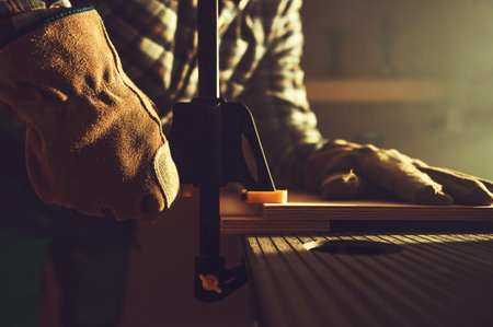 Closeup of Woodworking Clamp Tool Being Mounted by Professional Woodworker in His Workshop. Construction Equipment Theme.の写真素材