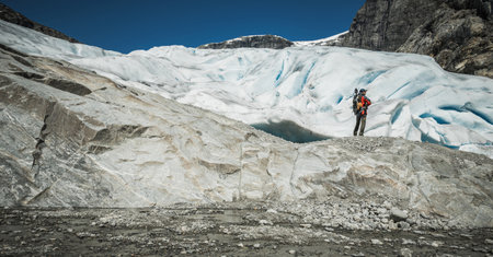 Norwegian Vestland County Glacier Exploration Trip. Caucasian Hiker Enjoying Spectacular Glacial Vista.の写真素材