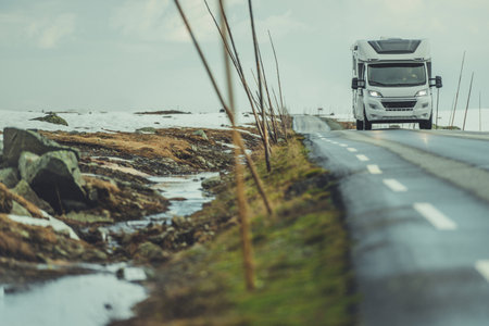 Family Crossing Norwegian Wilderness in a Camper Van RV. Modern Motorhome on Countryside Vestland County Road, Norway.の写真素材