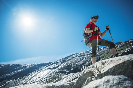 Norwegian High Mountains Caucasian Hiker on a Scenic Sunny Trail Along Glaciated Landscape.の写真素材