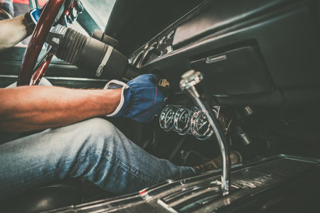 Classic Cars Professional Mechanic Examining a Vehicle While Seating Inside