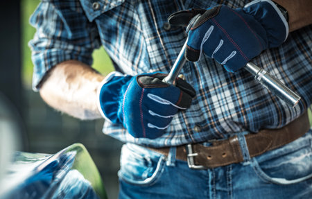 Caucasian Car Mechanic with a Wrench in His Hands Close Up. Automotive Industry Theme.の写真素材