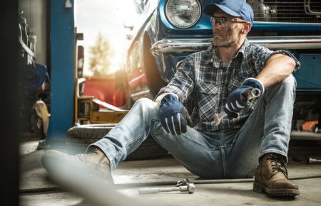 The Man and His Classic Car Restoration Project. Repairing Vintage Vehicle Inside His Garageの写真素材