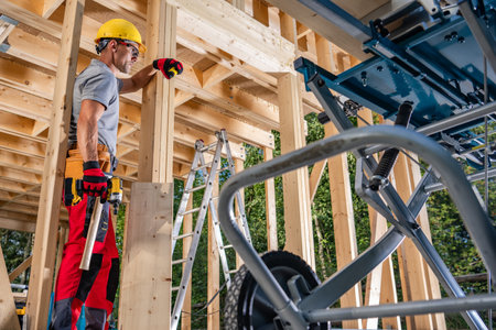 Professional Woodwork Construction Worker in Front of Wood Made House Skeleton Frame. Wearing Hard...