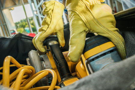 Construction Contractor Grabbing Power Tools From His Equipment Bag Close Up.