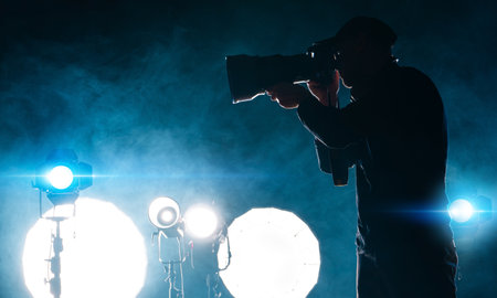 Modern Photographer with Digital Camera Taking Photos Inside Artificially Illuminated Studioの写真素材