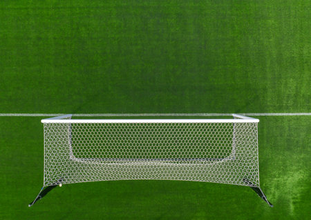 An aerial perspective showcases a soccer goal positioned on a vibrant green turf field under bright...