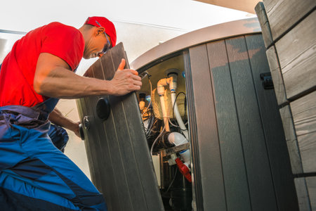 A technician inspects and maintains the internal components of a hot tub at a home, ensuring proper functionality and safety.の写真素材