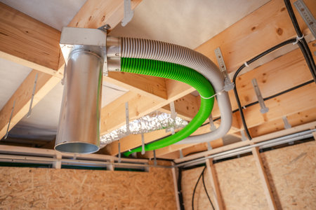 A ventilation system is being installed in a newly constructed home. The image shows colorful ductwork attached to the ceiling beams, indicating progress in the home's air quality management system.の写真素材