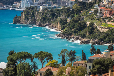 March 15, 2025 Monte Carlo, Monaco. The shoreline features stunning turquoise waters gently lapping against rocky cliffs adorned with lush greenery.の写真素材