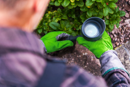 Caucasian Gardener Installing Garden Outdoor LED Lighting