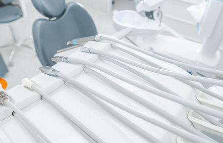Various dental instruments neatly arranged on a workstation in a bright clinic, awaiting the next patient. The environment is clean and organized.の写真素材