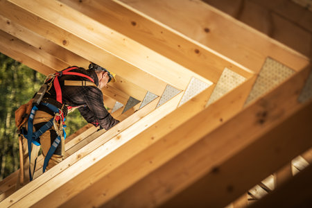 A construction worker is carefully climbing wooden beams to install roofing material in a serene...
