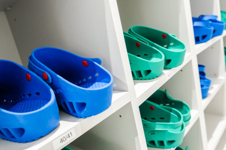 Footwear in blue and green is neatly arranged on shelves in a storage area.の写真素材