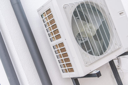 The air conditioning unit is attached to the wall of a building. It helps cool the interior space.の写真素材