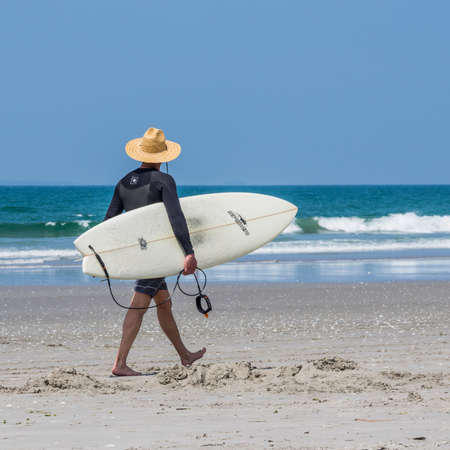 Surfer heading to the beach to check out the wavesの写真素材