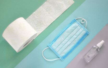 Coronavirus covid-19 virus prevention. Safety breathing masks, tissue toilet paper and hand sanitizer layout, top view, flat lay. Coronavirus flu virus concept. Health care and medical concept. Panic.の写真素材