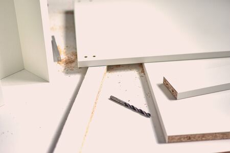 Man doing renovation work at home, drilling with a screwdriver. Group of repair tools on wooden...