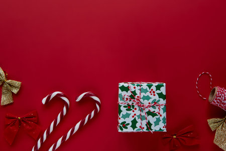 Christmas composition. Gifts, presents wrapped ribbon, lights, candy canes decorations on red background. Winter, new year Flat lay, top view, copy space. Template mockup greeting card text designの写真素材