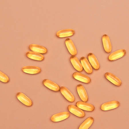 Many transparent pills Omega 3 or fish oil on a colorful background. Health supplements and medicinesの写真素材