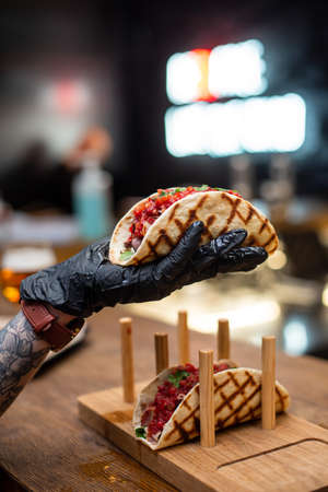 Traditional street mexican pork tacos with beef, tomatoes, avocado, chilli in yellow corn tortillaの写真素材