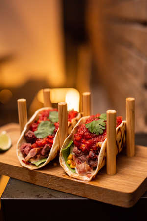 Traditional street mexican pork tacos with beef, tomatoes, avocado, chilli in yellow corn tortillaの写真素材