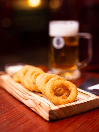 Assorted beer snacks, fast food. Onion rings with mug of beer.の写真素材