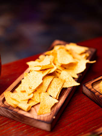 Assorted beer snacks, fast food. Nachos and chips and with mug of beer