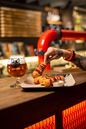 Assorted beer snacks, fast food. Fried Cheese Sticks, cured meats, nuggets with mug of beer.