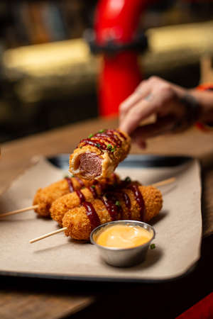 Assorted beer snacks, fast food. Fried Mozzarella Cheese Sticks, cured meats, nuggets cured meats pastrami, pickles, french fries, nachos, pistachios, chips and sauses with mug of beer.の写真素材