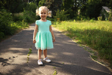 Portrait of a happy liitle blond girl close-up. 3 yaers caucasian todler girl smiling at outdoors walk. Kid dancing and shouting showing different emotions.の写真素材