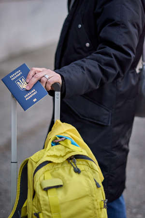 Evacuation of civilians, sad child with the flag of Ukraine. Refugee family from Ukraine crossing...