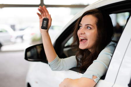 Young woman is happy about a new carの写真素材