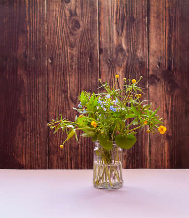 A vase of flowers sitting on top of a wooden tableundefined.の写真素材