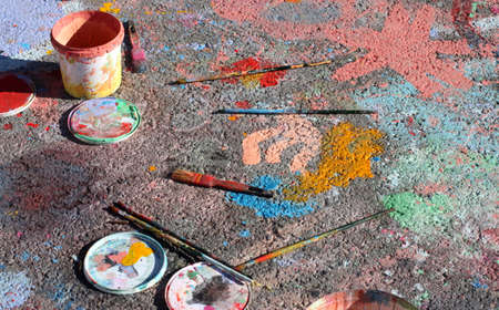Jars, lids and dirty used brushes on painted asphalt in natural light.の写真素材