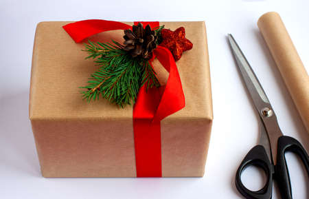 Step by step. Step 3. Wrapping a Christmas gift in craft paper and decorating it with fir branches and Christmas toys. Instructions for gift packaging.の写真素材