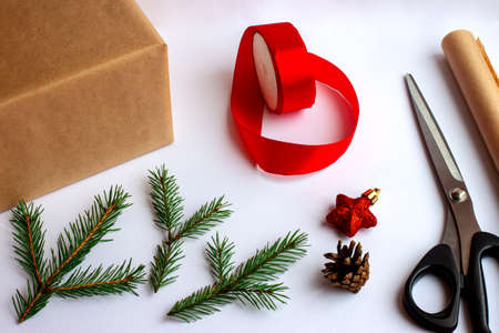 Step by step. Step 2. Wrapping a Christmas gift in craft paper and decorating it with fir branches...