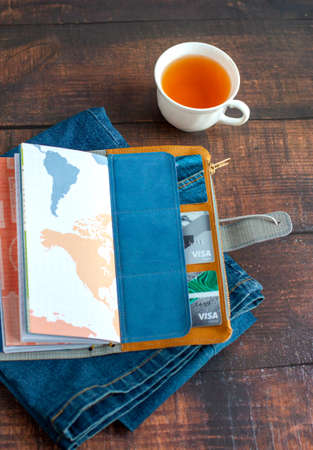 An open diary with a denim cover, pockets for plastic cards, lying on jeans against the background...