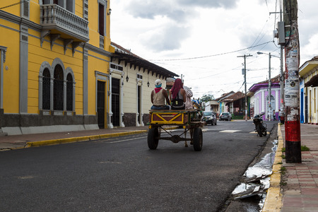 A horse & cart travels along a street in downtown Granada, Nicaragua.のeditorial素材