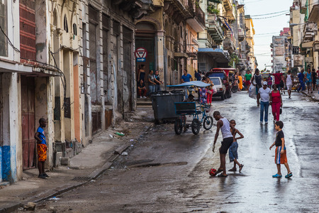 Four boys playing football on the streets of Havana.Between them all they had two gloves (one for each keeper who kept goal in doorways) & one flat red ball, but they were having a great time.のeditorial素材